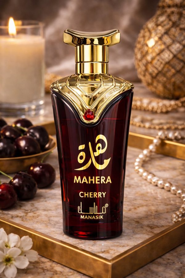 Парфюм Mahera Cherry, поставен върху декоративна повърхност с череши и златни аксесоари