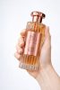 Парфюм Durrat Al Aroos Eau de Parfum, държан в ръка, със стъклен флакон и златисти детайли
